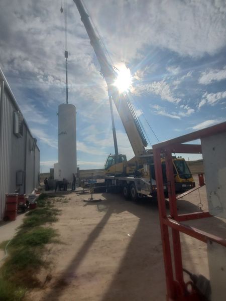 Crane setting the bulk storage tank during construction